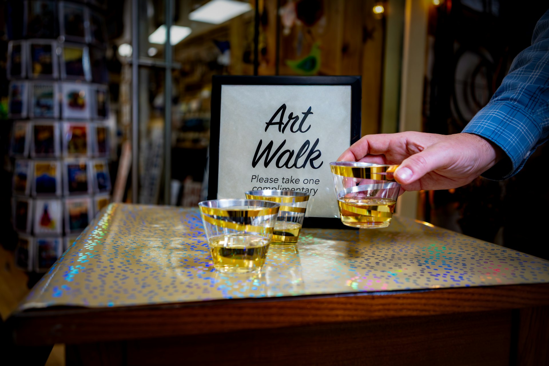 Hand taking small glass at art walk event